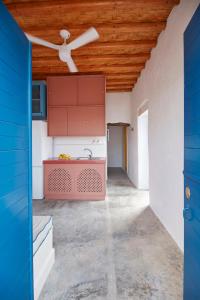 a kitchen with red cabinets and a ceiling fan at Kimolos View in Kimolos