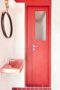 a red door in a bathroom with a sink at Kimolos View in Kimolos