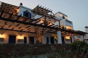 a large white house with a wooden pergola at Kionia Panorama Studios in Kionia