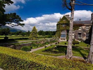 uma casa antiga com um jardim em frente em Glenbeigh Holiday Cottage - Tigin Mamo em Glenbeigh