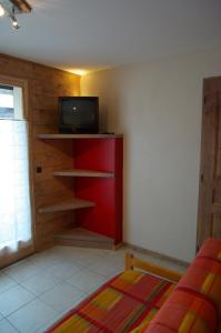 a living room with a tv and a red shelf at Appart Ressachaux Morzine centre 2 à 3 pers calme vue jardin parking in Morzine