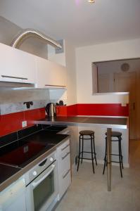 a kitchen with a sink and a counter with stools at Appart Ressachaux Morzine centre 2 à 3 pers calme vue jardin parking in Morzine +5 photos