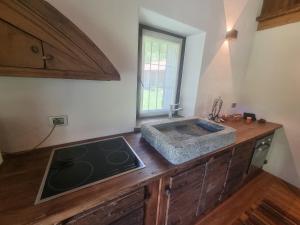 - une cuisine avec un évier et un comptoir dans l'établissement L'Atelier du Temps - Baita Grandes Jorasses, à Montita