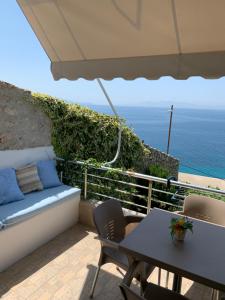 un patio con sofá, mesa y el océano en Blue Sea Apartments, en Qeparo