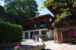 a cat sitting in front of a house at Appart Ressachaux Morzine centre 2 à 3 pers calme vue jardin parking in Morzine