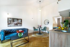 uma sala de estar com um sofá azul e uma mesa em Smile Apartments Bahnzeile em Krems an der Donau