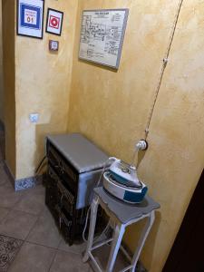 a fax machine sitting on a stool next to a wall at Disayn Hotel Shampan in Stavropol