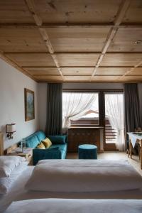 een slaapkamer met 2 bedden en een blauwe bank bij Mountain Home Villa Anna in Selva di Val Gardena +38 foto's