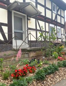 uma casa com um jardim de flores em frente em PferdeFairStand‘s Ferienwohnung 