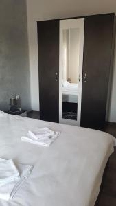 a bedroom with a white bed with a mirror at Apartament TEO in Caransebeş