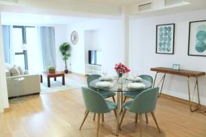 Apartments Olé - Albareda 24 في إشبيلية: غرفة طعام مع طاولة وكراسي في غرفة معيشة