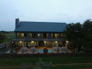 a large house with a patio and a pool at Game View Lodge in Vryburg