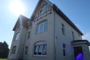 a large white building with windows on top of it at Lodge Boutique Hotel Kühlungsborn in Kühlungsborn