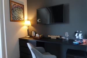 ein Zimmer mit einem Schreibtisch mit Fernseher und einem Stuhl in der Unterkunft Lodge Boutique Hotel Kühlungsborn in Kühlungsborn