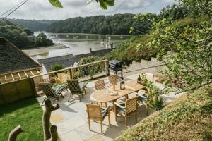 d'une terrasse avec une table et des chaises donnant sur la rivière. dans l'établissement Finest Retreats - Tideway, à Saint Clement