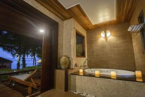 a bathroom with a tub with a view of the ocean at Tup Kaek Sunset Beach Resort-SHA Plus in Tab Kaek Beach