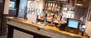 a bar with a counter with bottles of alcohol at The Spread Eagle in Manchester