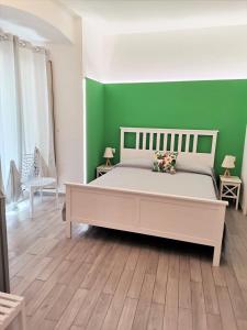 ein Schlafzimmer mit einem großen Bett und einer grünen Wand in der Unterkunft DG Sicily in Catania