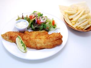 a plate of food with fish and a salad and fries at Oliver's Seafood Bar, Bed & Breakfast in Cleggan