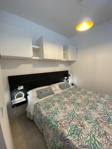 een slaapkamer met een bed met een groen en wit dekbed bij Torregrande Apartments in Torre Grande