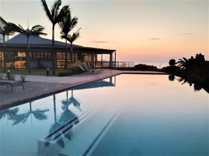 une villa avec une piscine en face d'une maison dans l'établissement Premier Resort Cutty Sark, à Scottburgh