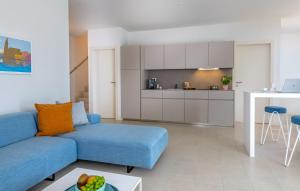 a living room with a blue couch and a kitchen at Pareus Beach Resort in Caorle