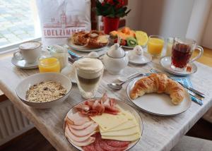 a table topped with plates of breakfast foods and drinks at Gästehaus Edelzimmer in Rothenburg ob der Tauber