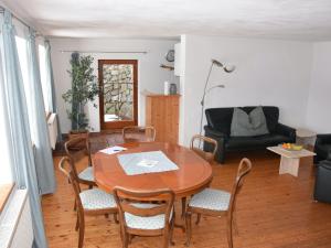 un soggiorno con tavolo, sedie e divano di Holiday home in Herrischried with garden a Herrischried