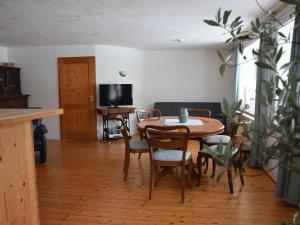 a dining room with a table and chairs and a television at Holiday home in Herrischried with garden in Herrischried