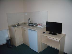 a small kitchen with a desk with a television on it at Penzion Iris in Rajecké Teplice