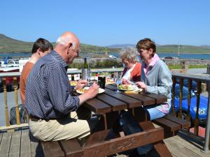 a group of people sitting at a picnic table at Oliver's Seafood Bar, Bed & Breakfast in Cleggan