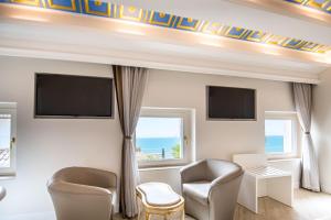 een woonkamer met 2 stoelen en een flatscreen-tv bij Opera Arte Conero Riviera in Numana