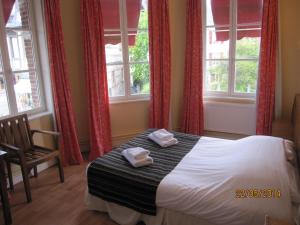 a bedroom with a bed with two towels on it at La Taverne des Deux Augustins in Étretat