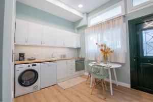 a kitchen with a washing machine and a table at The Nest Corfu Town in Agios Rokkos