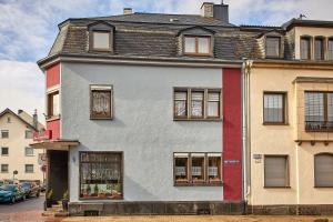 a white building with windows on a street at Hotel zum dicken Baum in Mayen