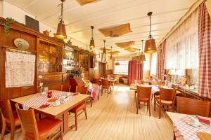 a restaurant with wooden tables and chairs and a bar at Hotel zum dicken Baum in Mayen