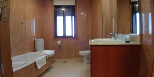 La salle de bains est pourvue d'une baignoire, d'un lavabo et de toilettes. dans l'établissement 9 Olas, à A Lanzada