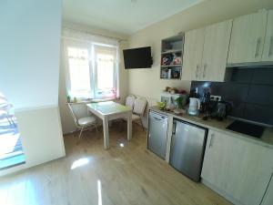 a small kitchen with a table and a table and chairs at Apartament Nemo in Rowy