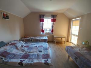 a bedroom with two beds and a table and two windows at Apartament Nemo in Rowy