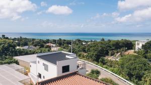 a white house with a view of the ocean at ととのいVilla YAE in Motobu