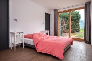 a bedroom with a bed and a large window at CHALET ALTAÏ in Séez