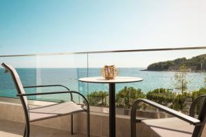a table and chairs on a balcony with a view of the ocean at Soñar en el mar in Himare
