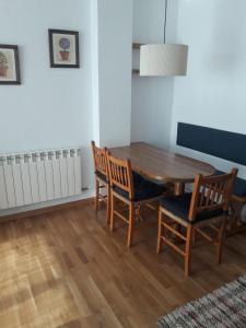 una sala da pranzo con tavolo e sedie in legno di Agradable apartamento con jardín privado en Cerler a Cerler