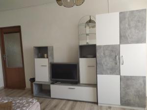 a living room with a tv and white cabinets at Penzion Renata in Třeboň