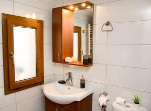 a bathroom with a sink and a mirror at Limnos IRiS Apartments in Agios Ioannis Kaspaka +64 photos