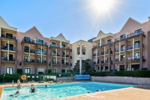 een groep mensen in een zwembad voor appartementsgebouwen bij Résidence Pierre & Vacances L'Archipel in Perros-Guirec