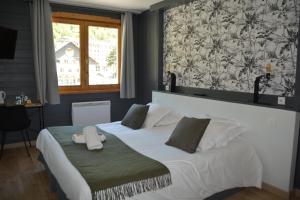 a bedroom with a large white bed with a window at Cit'Hôtel le Welcome in Moutiers