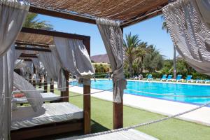 a resort with a swimming pool with a hammock next to a resort at Kampaoh Los Escullos in Almería