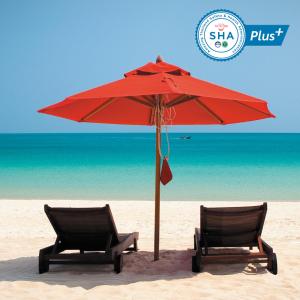 
two umbrellas sit on a beach near the ocean at Anantara Rasananda Koh Phangan Villas - SHA Plus in Thong Nai Pan Noi
