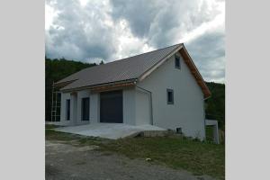 una casa blanca con un garaje en un campo en St Jean de Crots, wifi, TV, machine à laver., en Crots